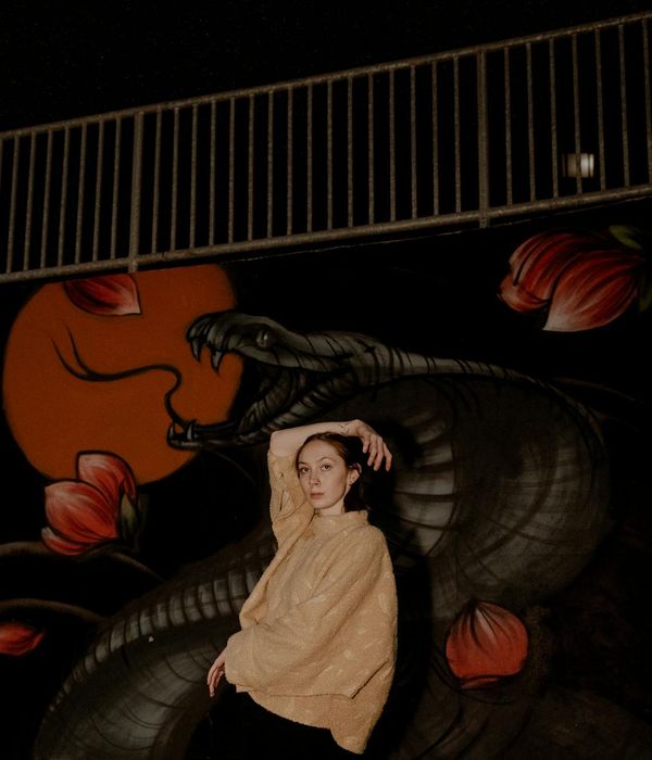 Person in a dynamic yoga pose against a dark background.